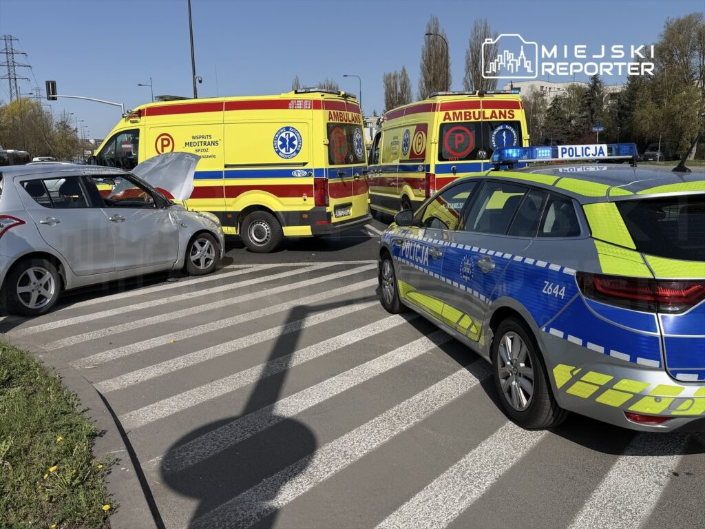 Zderzenie dwóch pojazdów na skrzyżowaniu, obok parkujące karetki pogotowia i radiowóz policji.