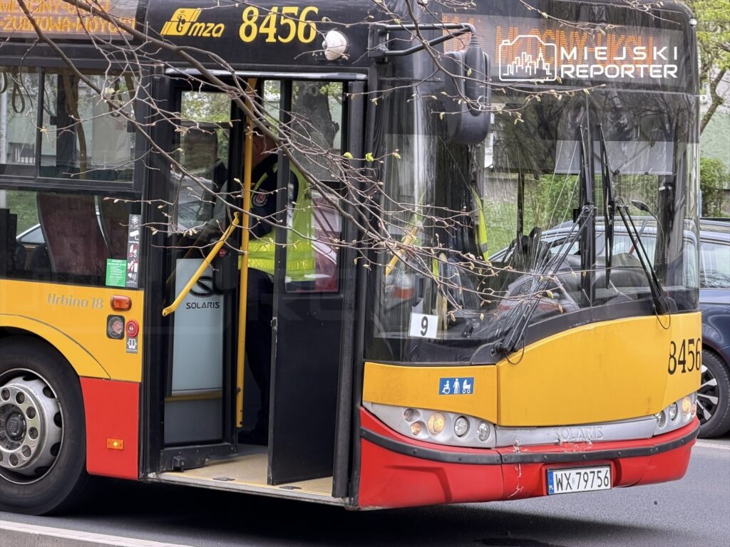 Autobus miejski Solaris Urbino 18 stoi na przystanku, otwarte drzwi umożliwiają wejście pasażerów.