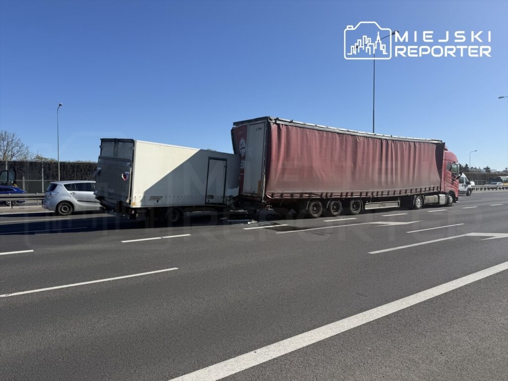 Dwa ciężarówki stojące obok siebie na drodze, jedna z naczepą w kolorze czerwonym, druga biała.
