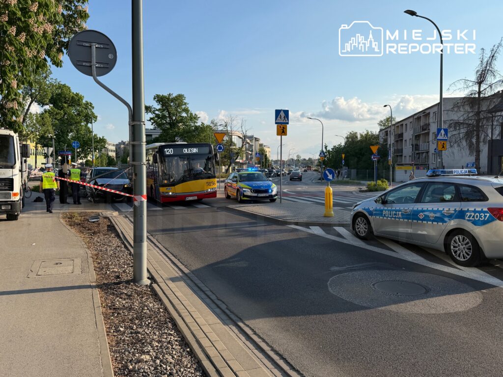 Policjanci prowadzący dochodzenie przy zablokowanej drodze, obok przystanku autobusowego z linią 120.