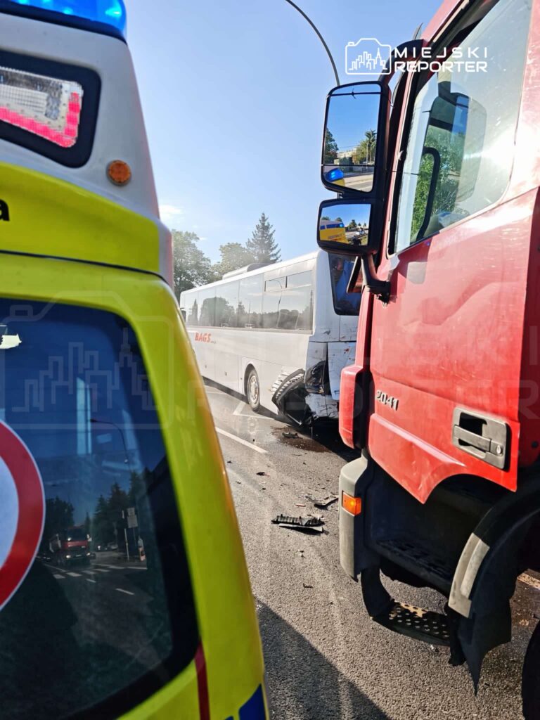 Wielki wypadek drogowy z udziałem autobusu i ciężarówki na ulicy, z widocznymi uszkodzeniami pojazdów.