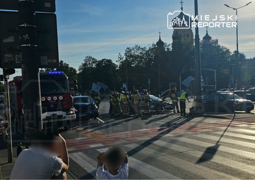Na skrzyżowaniu strażacy i ratownicy medyczni udzielają pomocy po wypadku drogowym z udziałem dwóch samochodów osobowych.