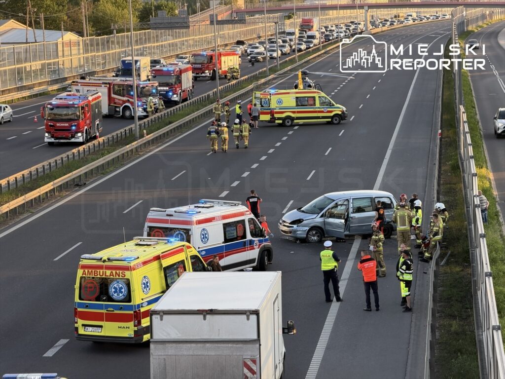 Na autostradzie zatrzymane pojazdy ratunkowe, strażacy oraz policja udzielają pomocy po wypadku samochodowym.