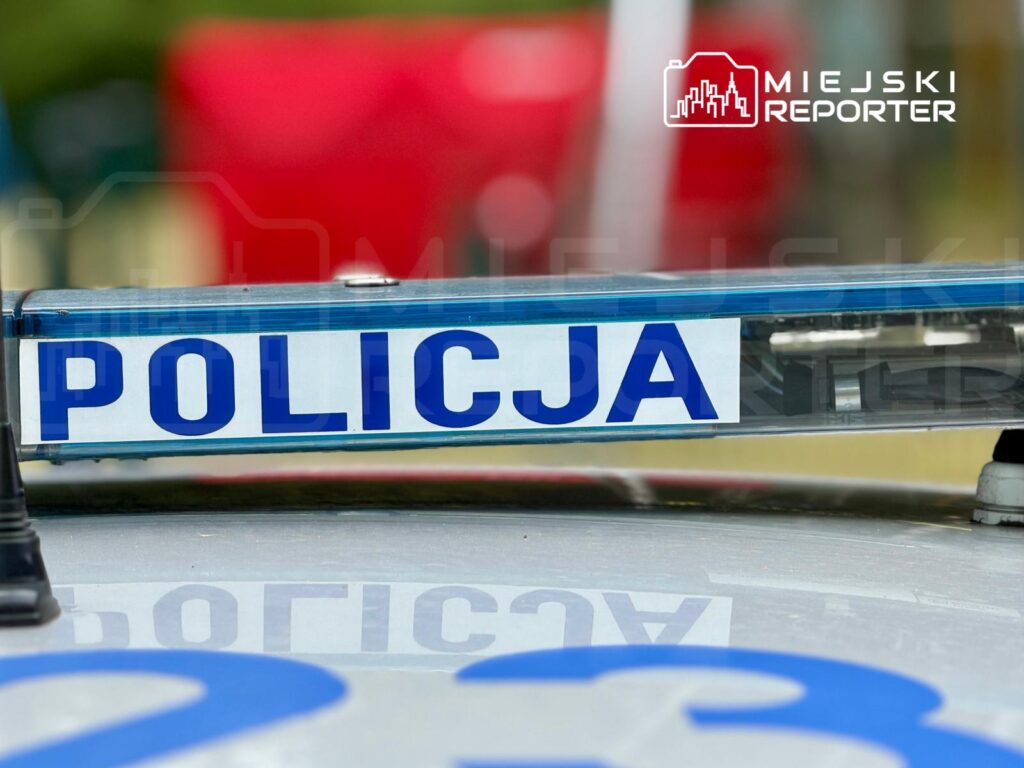 Niebieska sygnalizacja świetlna na dachu radiowozu policyjnego z napisem "POLICJA" w jasnym otoczeniu.