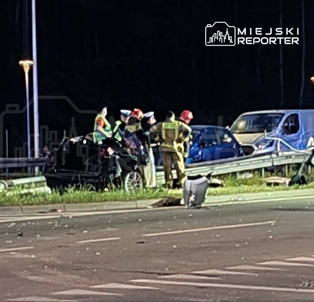 Grupa ratowników i policjantów bada miejsce wypadku drogowego, gdzie zderzyły się dwa pojazdy.