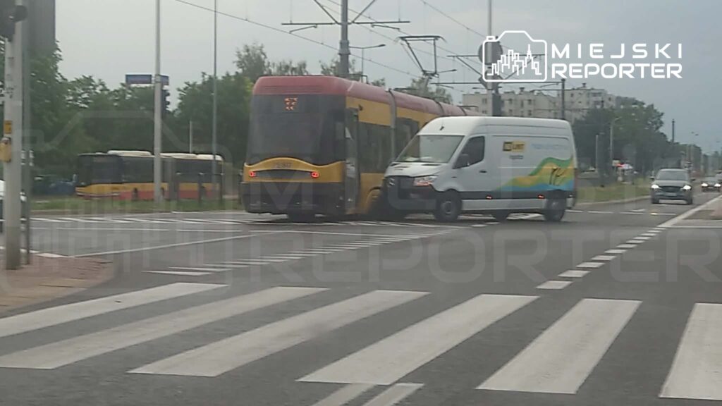 Tramwaj z żółto-czerwonymi elementami zderza się z białym furgonetką na przejściu dla pieszych.