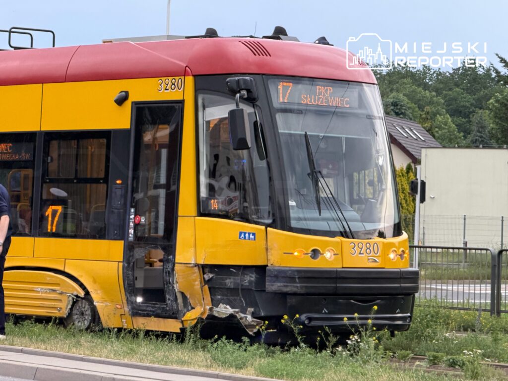 Tramwaj linii 17 z numerem 3280 zatrzymany na torowisku, z uszkodzoną tylną częścią, w tle zieleń i zabudowa.