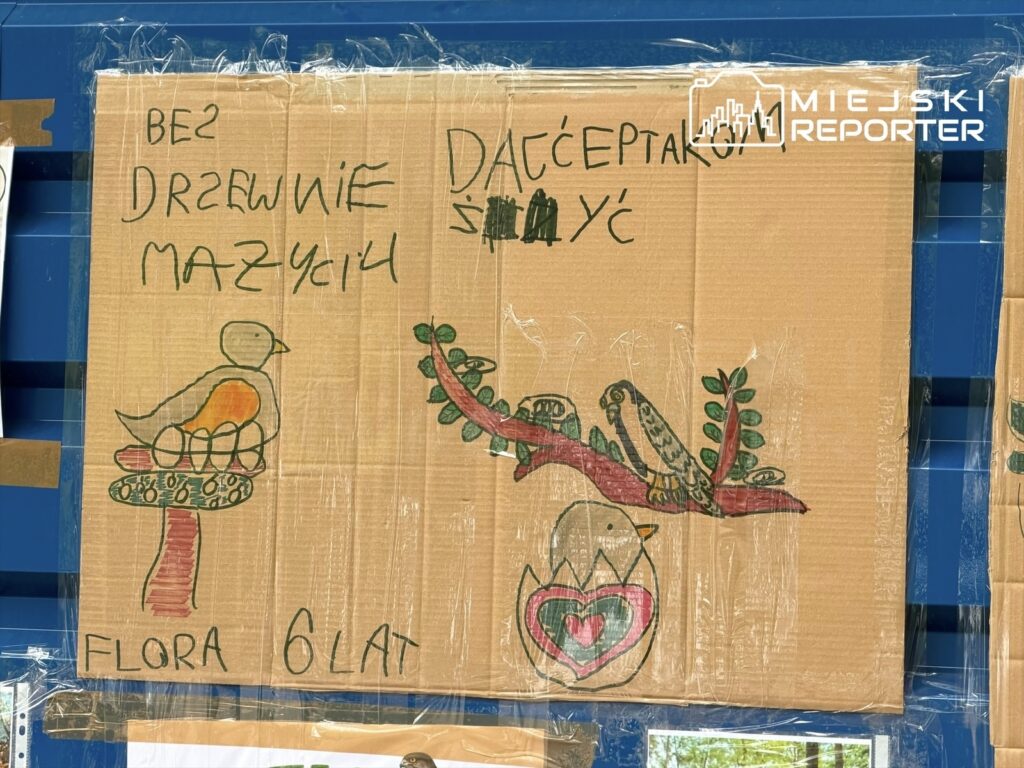 Na kartonie z kolorowymi rysunkami ptaków i roślinami widnieje napis: "BEZ DRZEW NIE MA ŻYCIA" oraz "FLORA 6 LAT".