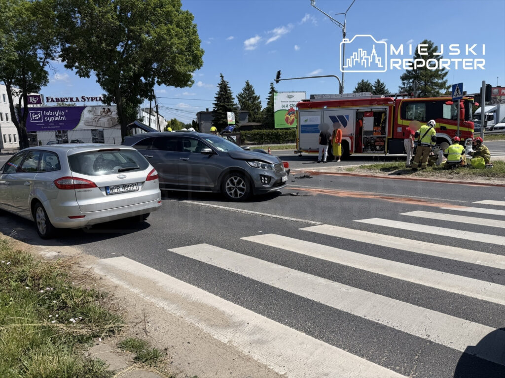Na skrzyżowaniu ulic, zespół ratunkowy udziela pomocy poszkodowanym w wyniku kolizji samochodowej.