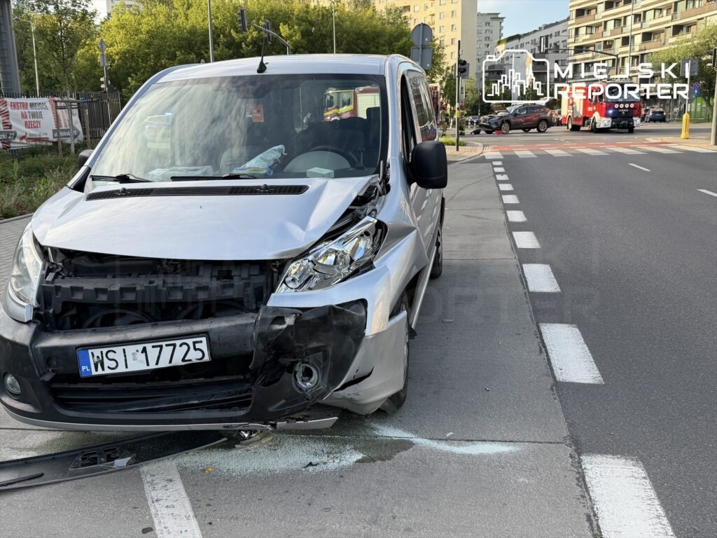 Uszkodzony samochód dostawczy zaparkowany na poboczu drogi, z widocznymi uszkodzeniami przedniego zderzaka.