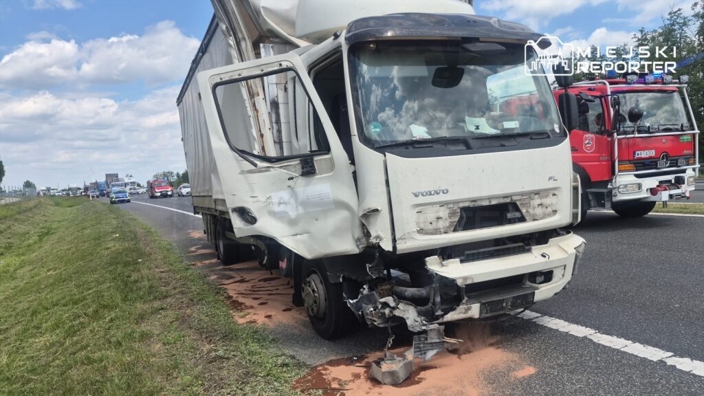Uszkodzony ciężarowy pojazd marki Volvo stoi na poboczu drogi, obok widać straż pożarną i pojazdy w ruchu.