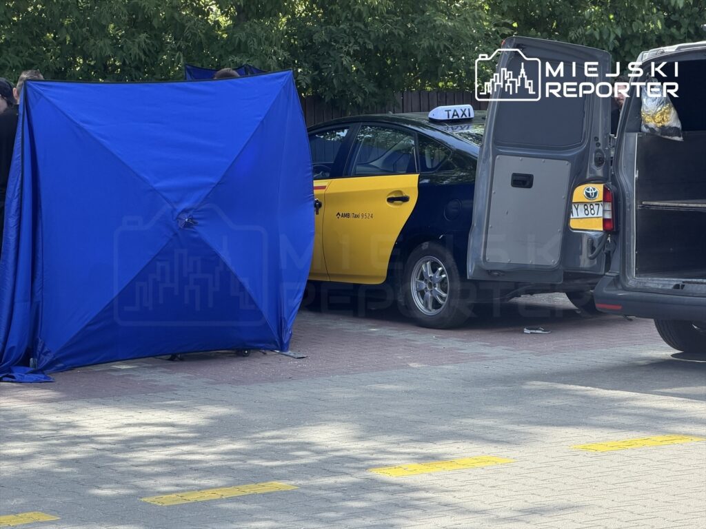 Grupa osób ustawia niebieski namiot w pobliżu taksówki w miejskim otoczeniu.