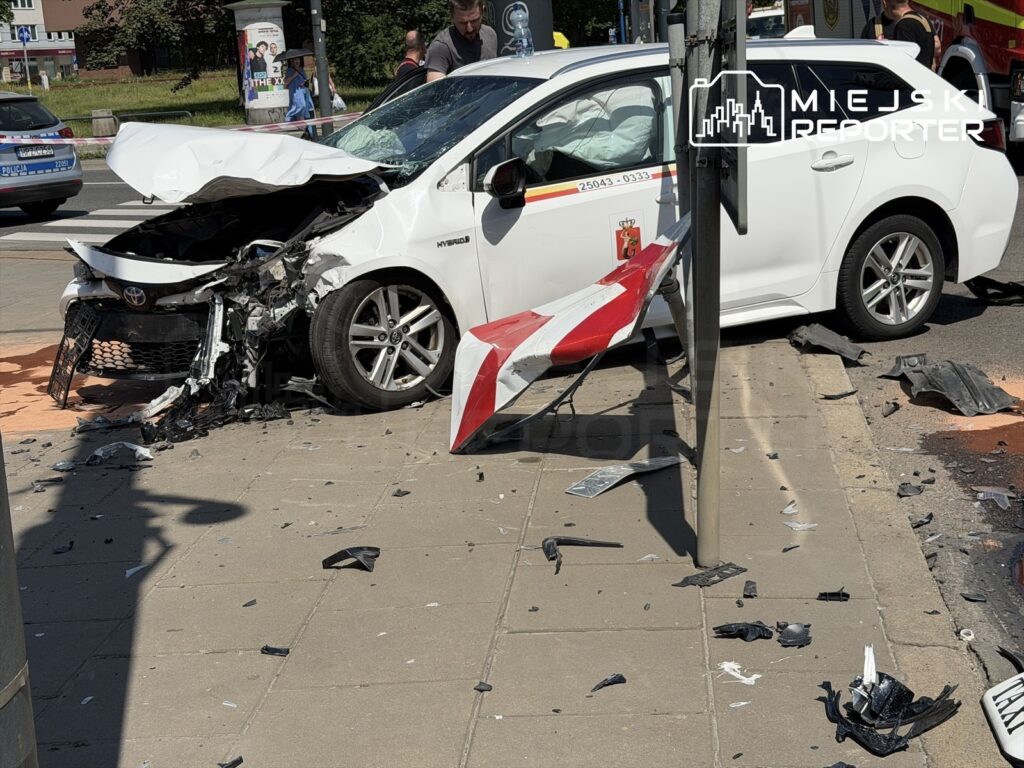 Zderzenie dwóch samochodów osobowych na skrzyżowaniu, z uszkodzoną przednią częścią jednego z pojazdów.