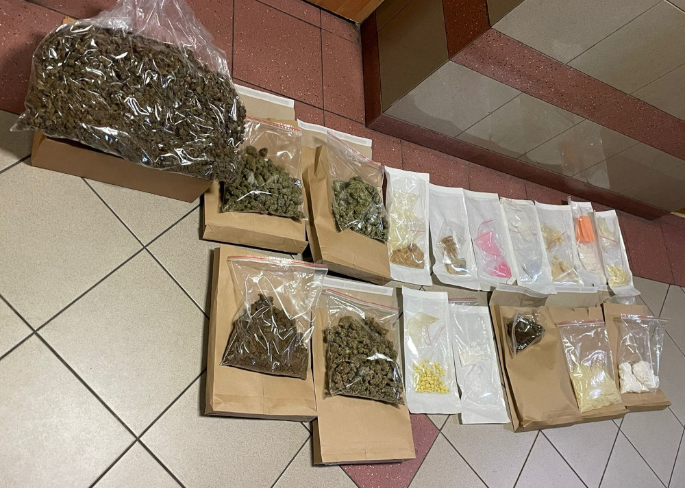 Zabezpieczone torebki z różnymi rodzajami narkotyków, w tym marihuaną, na podłodze w pomieszczeniu.