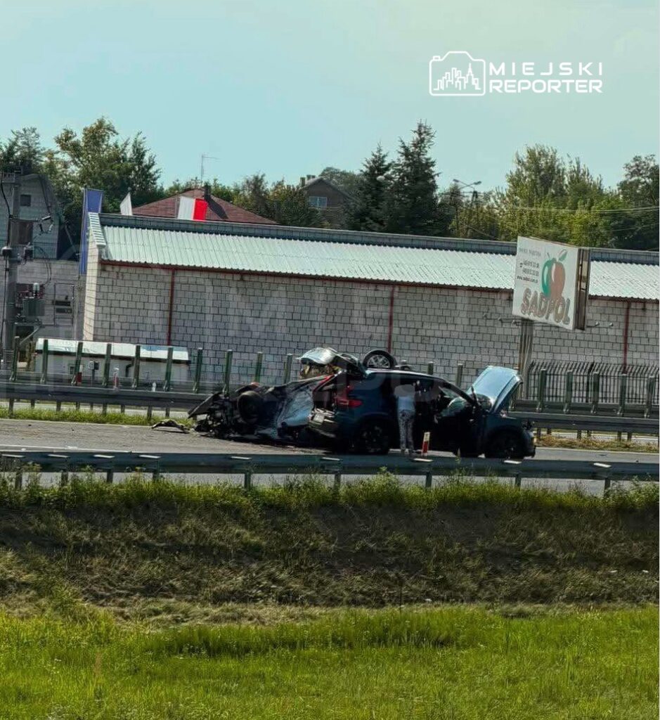 Wypadek drogowy z przewróconym samochodem na autostradzie, obok stojący mężczyzna sprawdzający stan pojazdu.