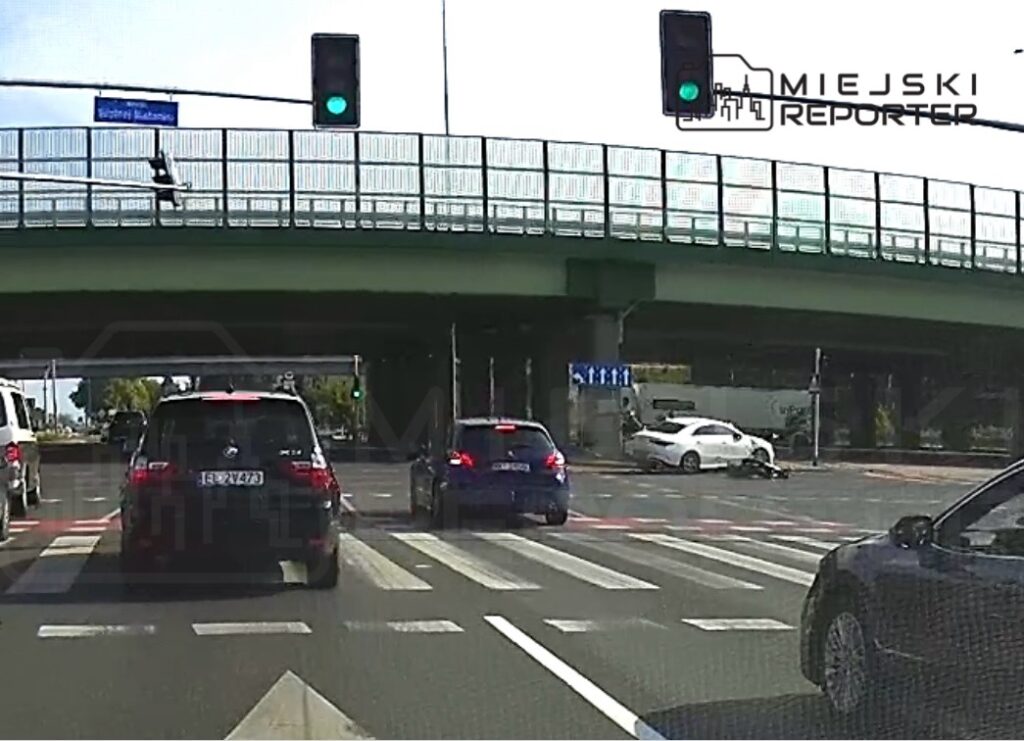 Ruchliwe skrzyżowanie z sygnalizacją świetlną, na którym samochody czekają na zielone światło.