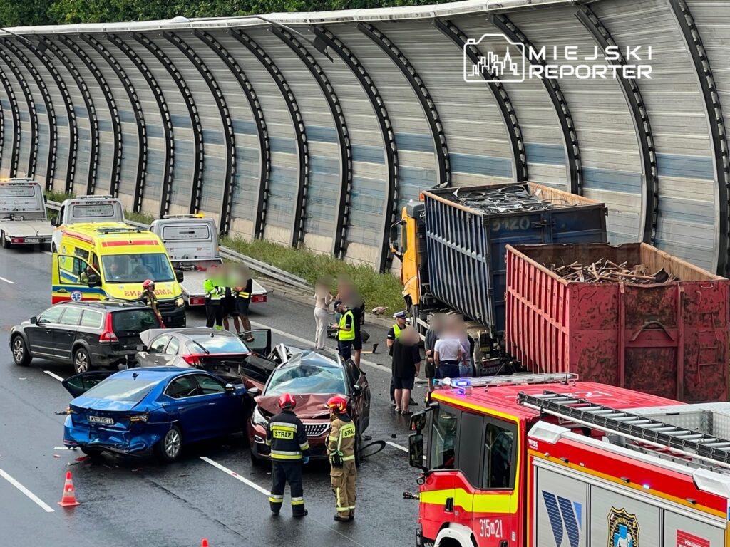 Wielki wypadek drogowy z udziałem kilku samochodów osobowych i ciężarówki na autostradzie, z interwencją służb ratunkowych.