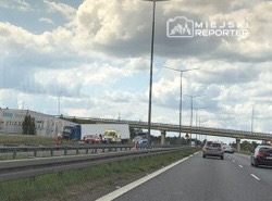 Kierowcy poruszający się po drodze szybkiego ruchu obok miejsca zdarzenia z udziałem ciężarówki.