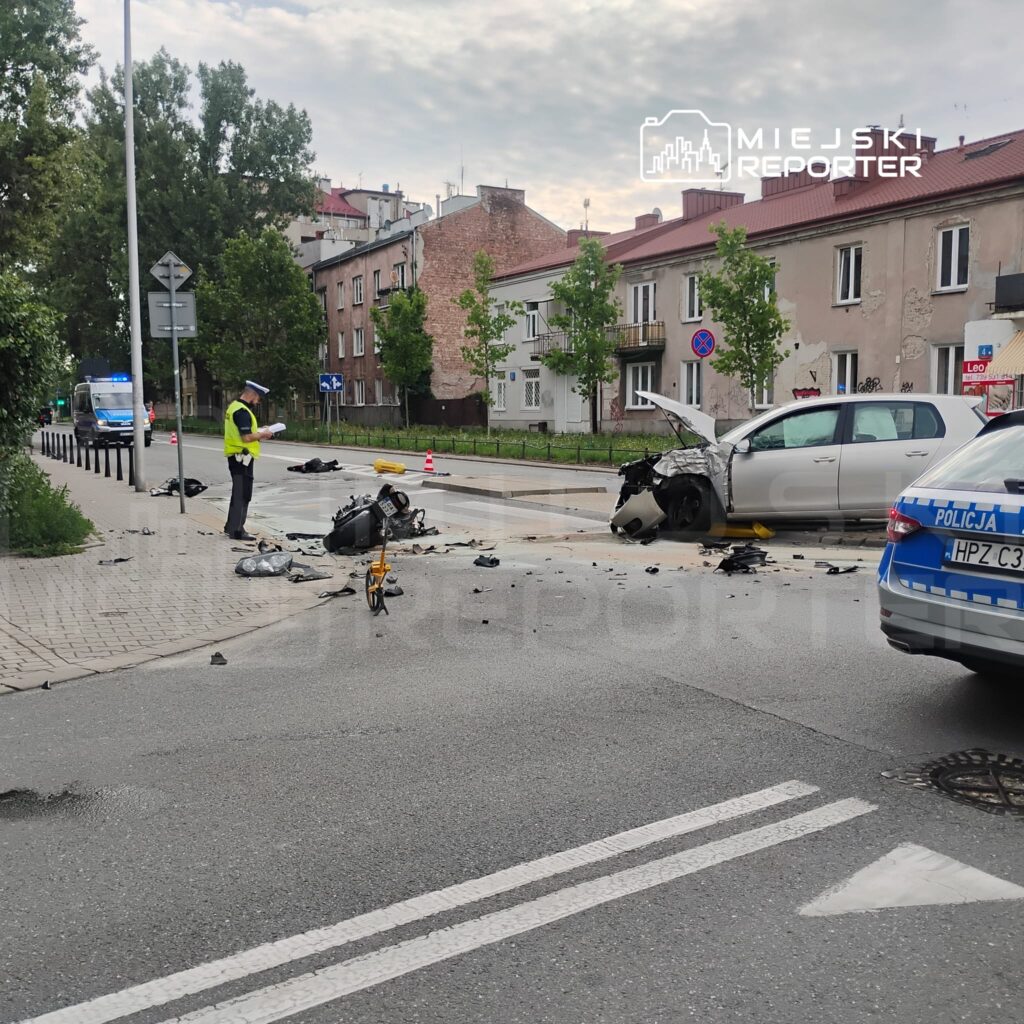 Policjant w kamizelce odblaskowej bada miejsce wypadku, gdzie zderzyły się dwa samochody na miejskiej ulicy.