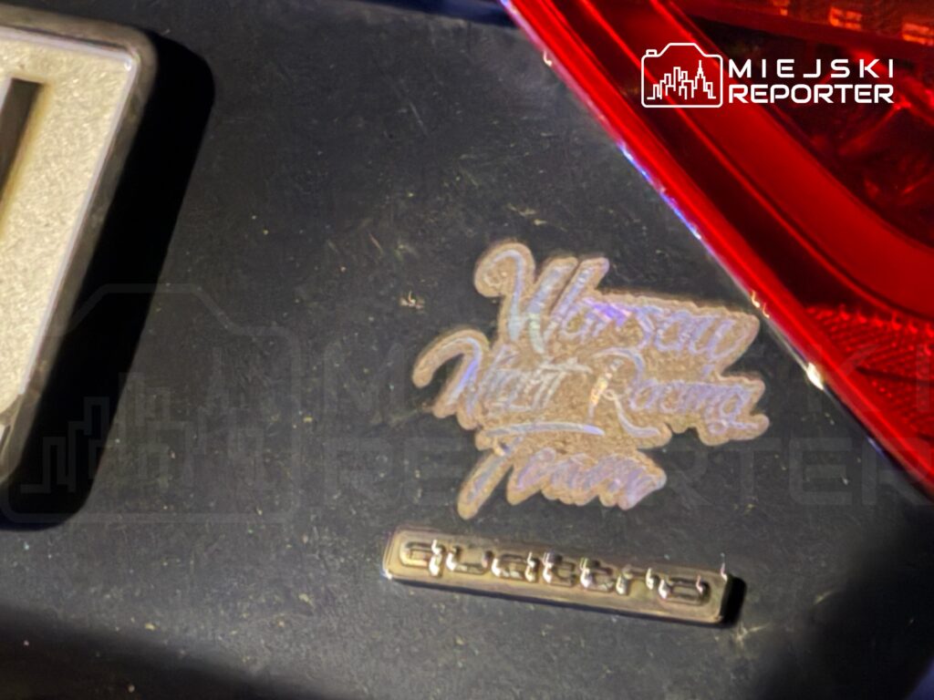 Na tylnej części samochodu znajduje się naklejka z napisem „Warszaw Mistrz Rzema Team” obok logo marki.