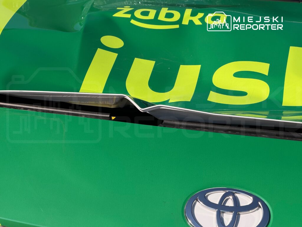 Zielona pokrywa samochodu z logo Toyoty i napisem "Zabko" oraz "jus" w jasnym kolorze.