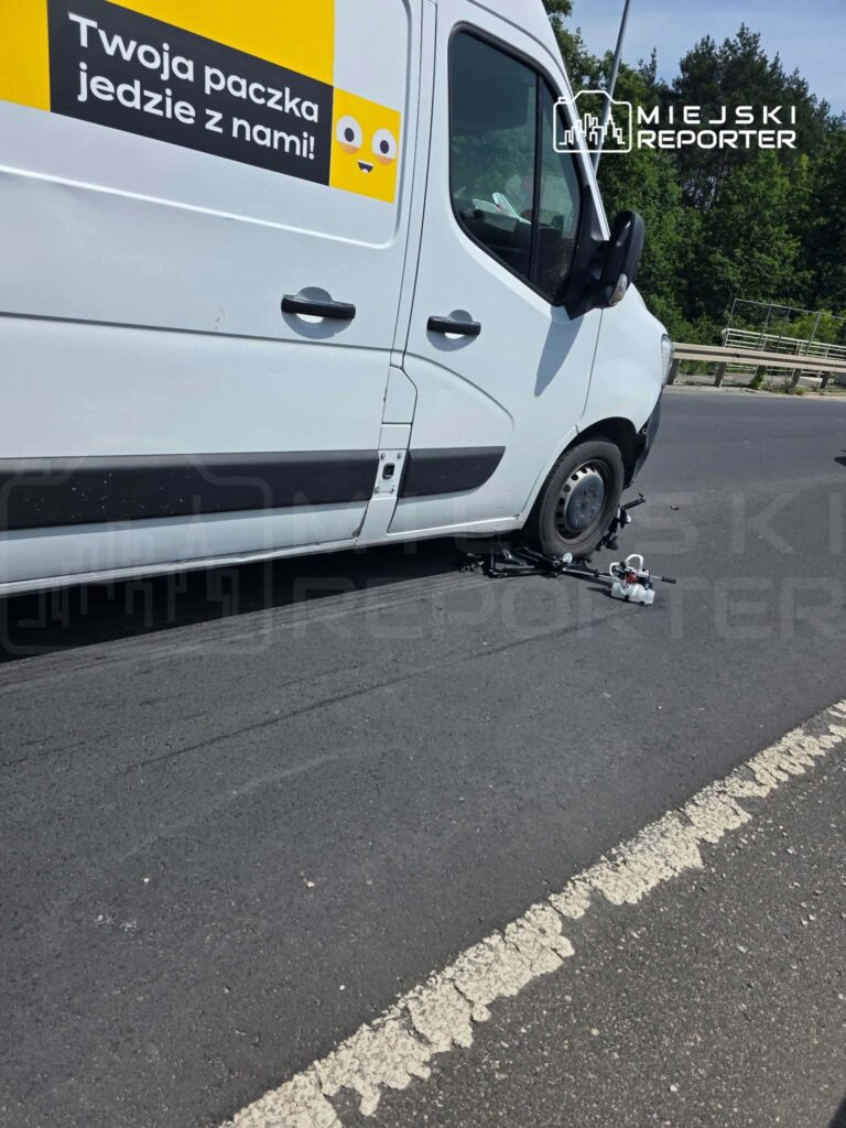 Zepsuty samochód dostawczy na drodze, z widocznymi uszkodzeniami kół i otaczającą zielenią.