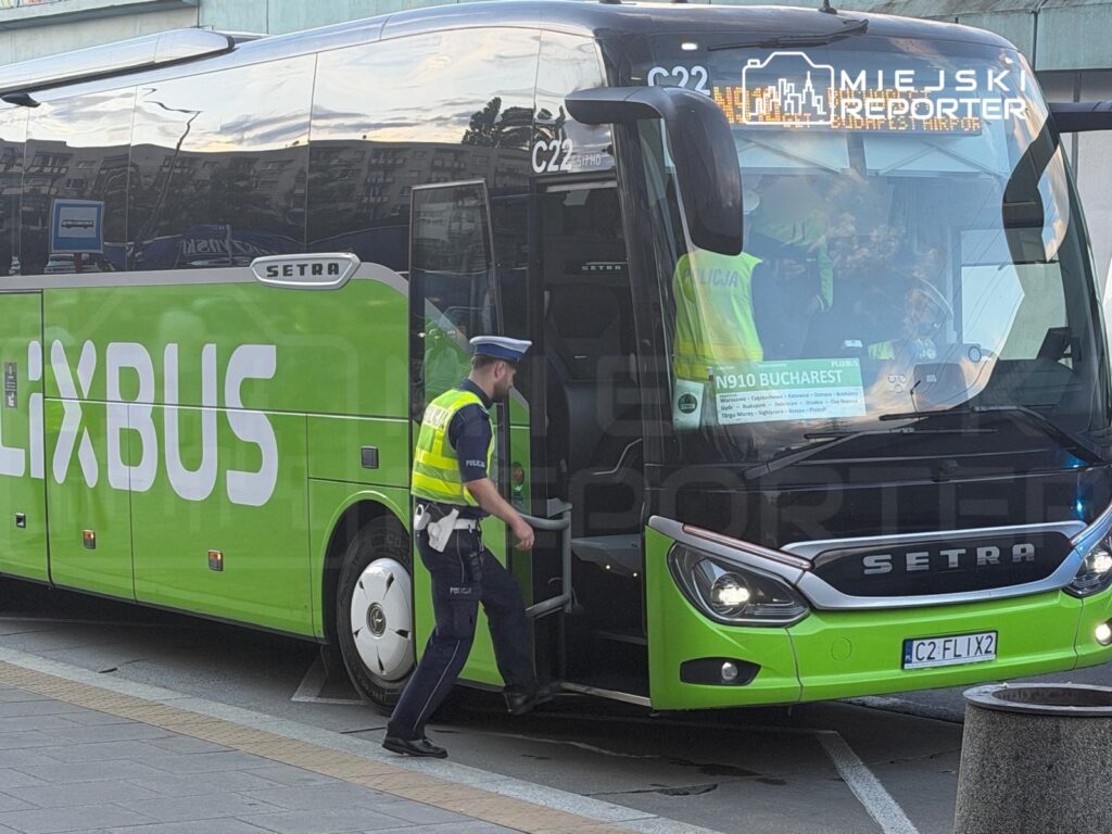 Policjant w kamizelce odblaskowej wchodzi do autobusu FlixBus w zielonym kolorze na przystanku.