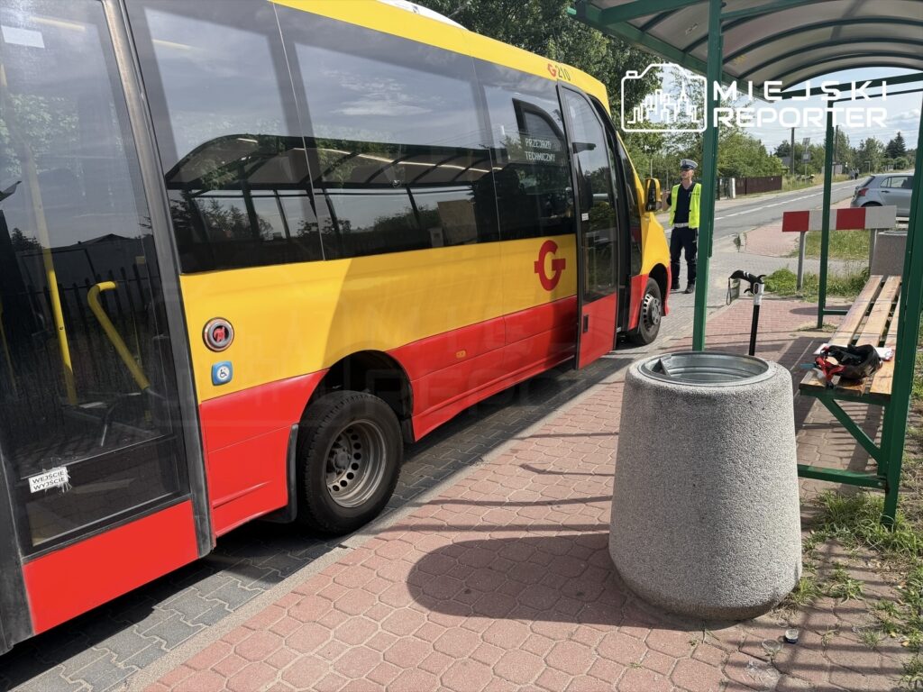 Autobus komunikacji miejskiej zatrzymał się na przystanku, obok stoi pracownik w kamizelce odblaskowej.
