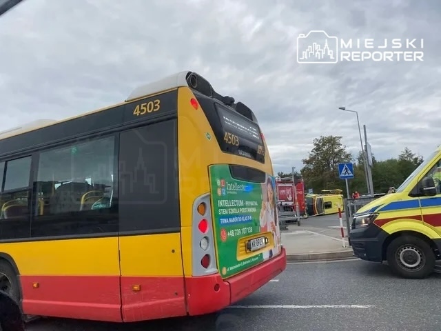 Autobus miejski o numerze taborowym 4503 zatrzymany w ruchu, obok widoczny pojazd ratunkowy.