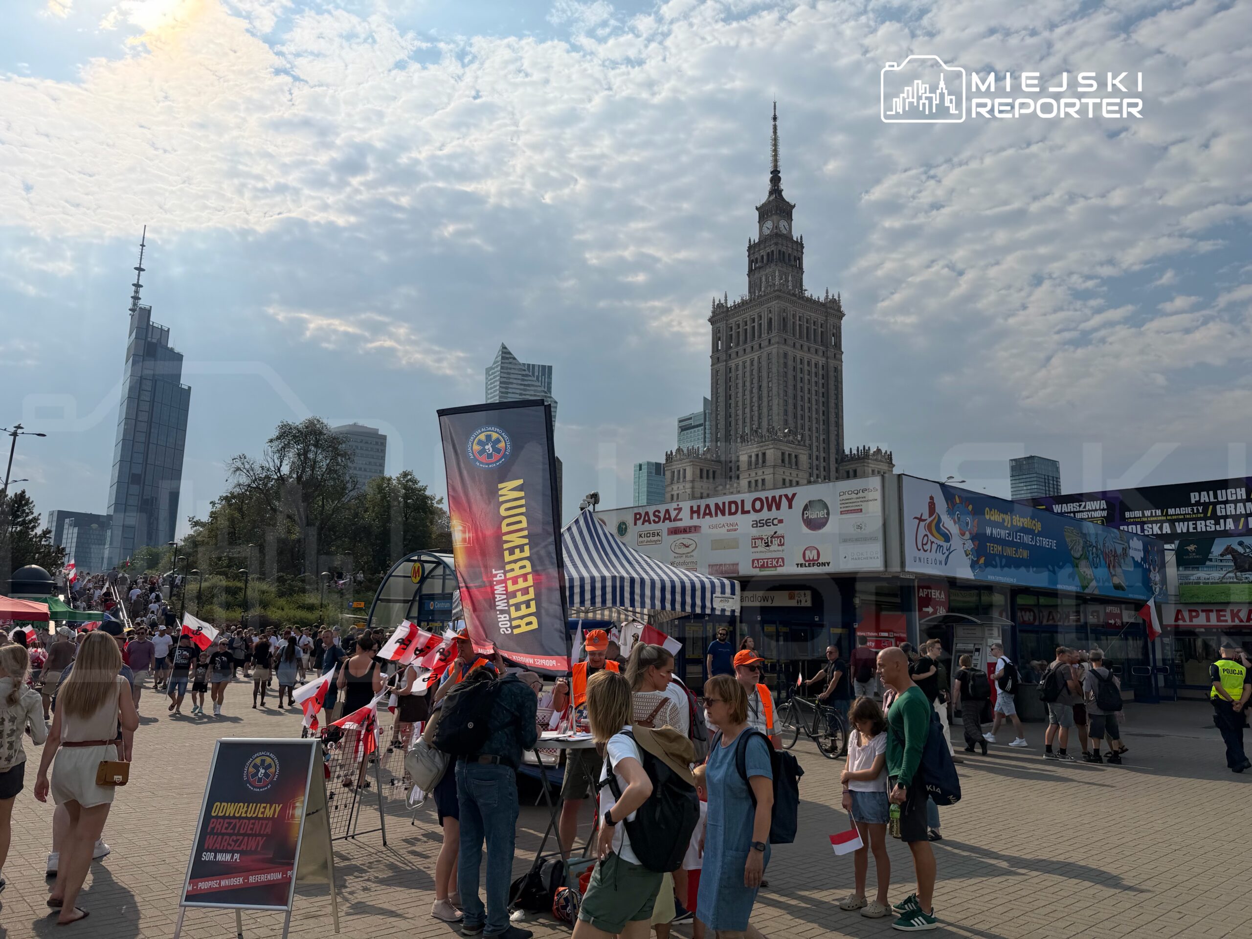 Tłum ludzi z flagami w rękach uczestniczy w wydarzeniu na placu przed Pałacem Kultury i Nauki.