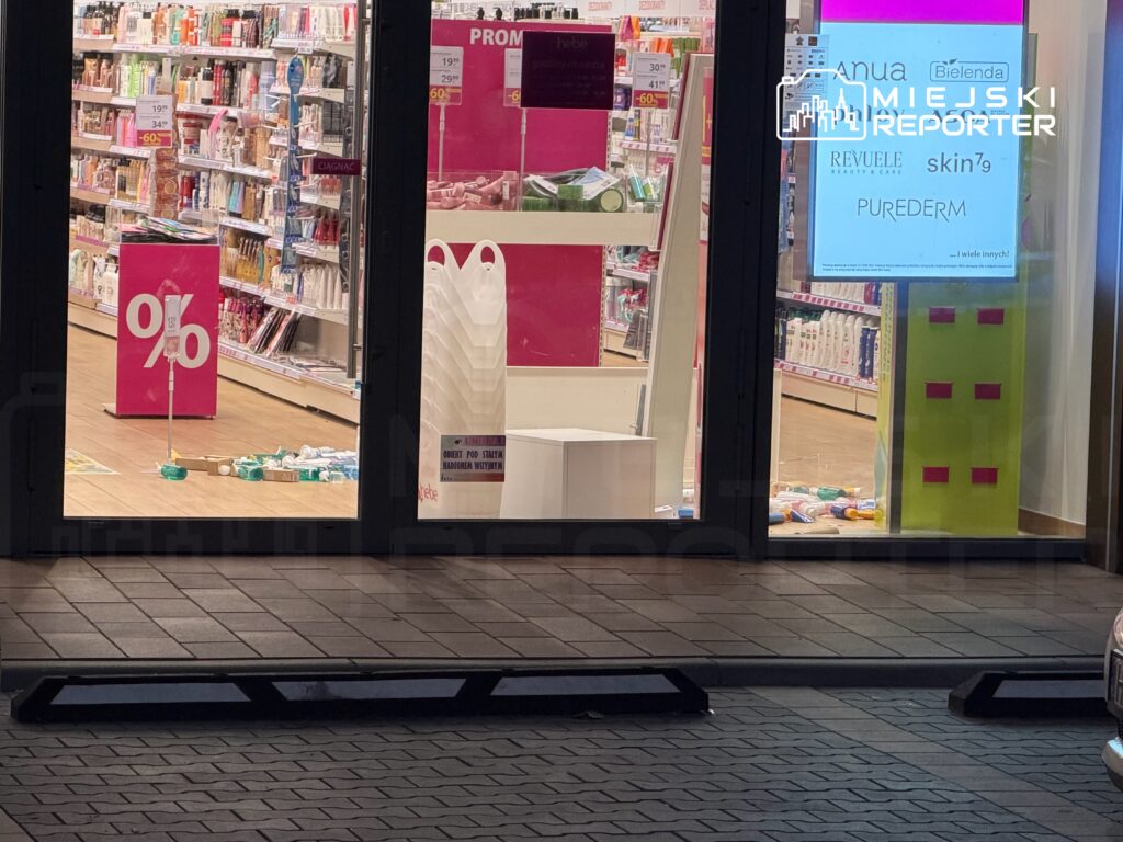 Sklep z kosmetykami z widocznymi promocjami i przewróconymi produktami na podłodze. W tle regały z artykułami.