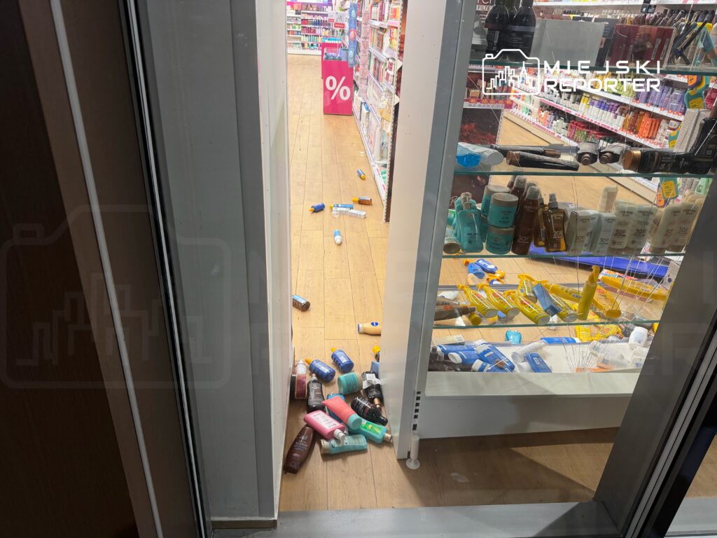Na podłodze sklepu leżą przewrócone opakowania kosmetyków, w tym szampony i balsamy.