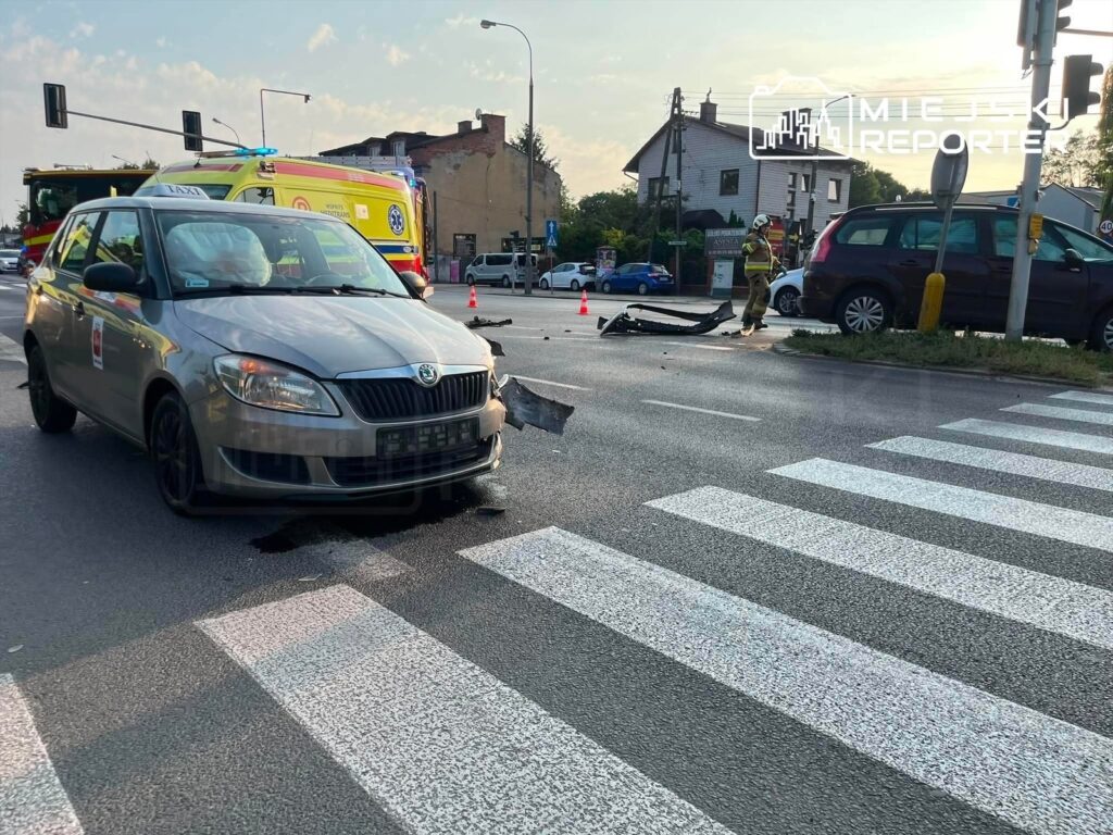 Zniszczony samochód osobowy stoi na pasach, obok widać strażaka i uszkodzone elementy drogi.