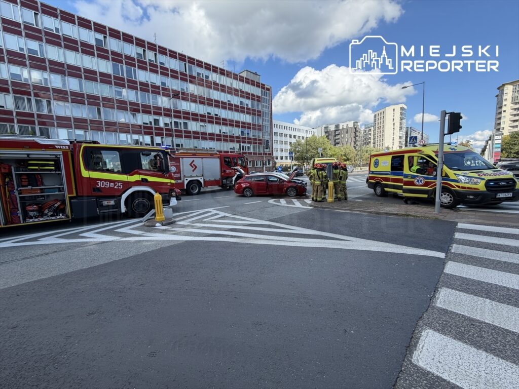 W centrum miasta strażacy i ratownicy medyczni udzielają pomocy poszkodowanym w wyniku wypadku samochodowego.