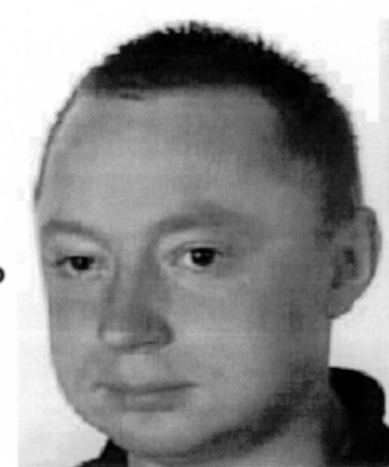 Mężczyzna z krótkimi włosami i neutralnym wyrazem twarzy, patrzący w obiektyw aparatu.