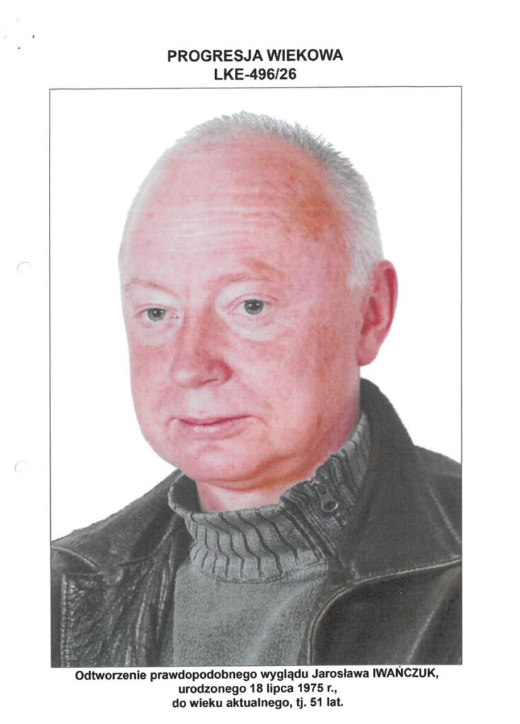 Mężczyzna w ciemnej kurtce z widocznym kapturem, z poważnym wyrazem twarzy, na białym tle.
