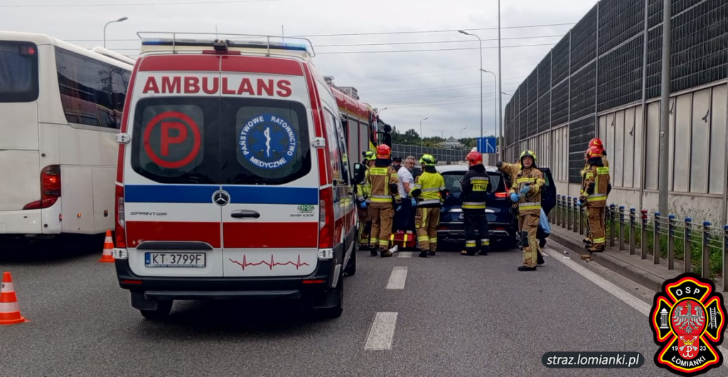 strażacy odbierający poród w samochodzie z pomocą zespołu medycznego.
