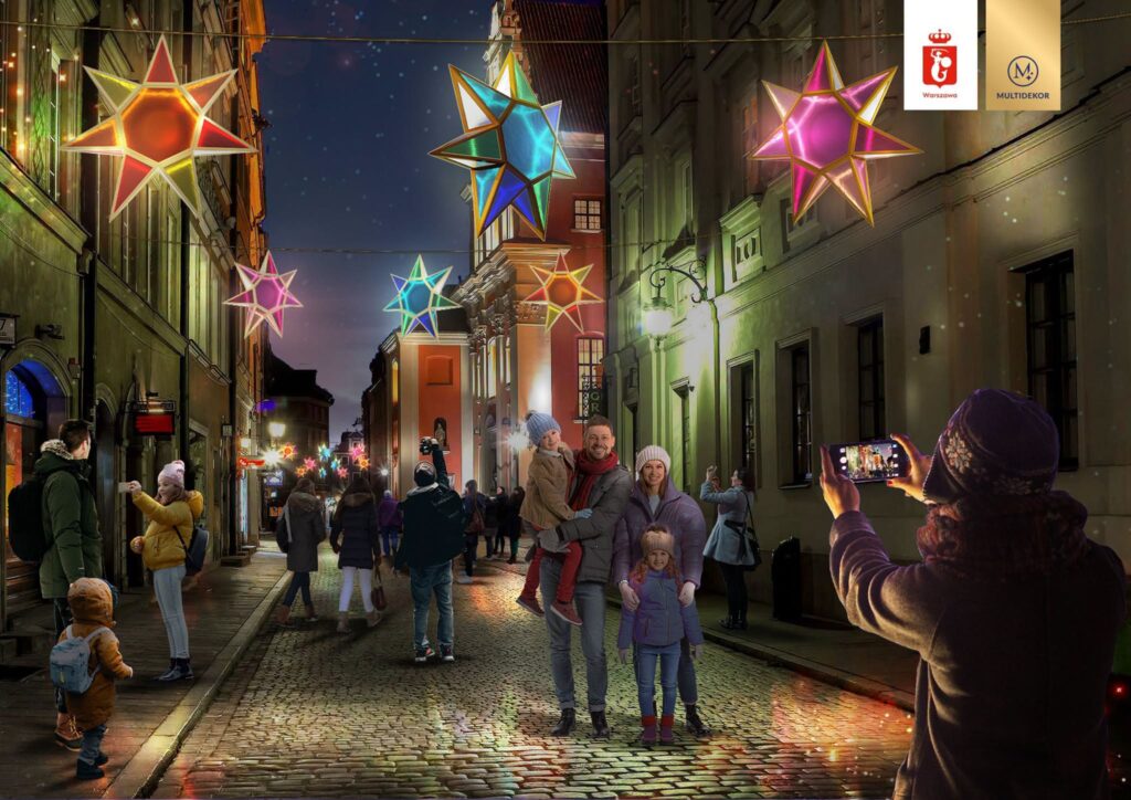 Rodzina z dziećmi pozująca do zdjęcia na oświetlonej ulicy, ozdobionej kolorowymi gwiazdami.