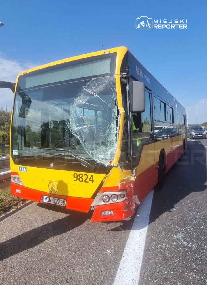 Zniszczony autobus komunikacji miejskiej z pękniętą szybą czołową stoi na drodze.