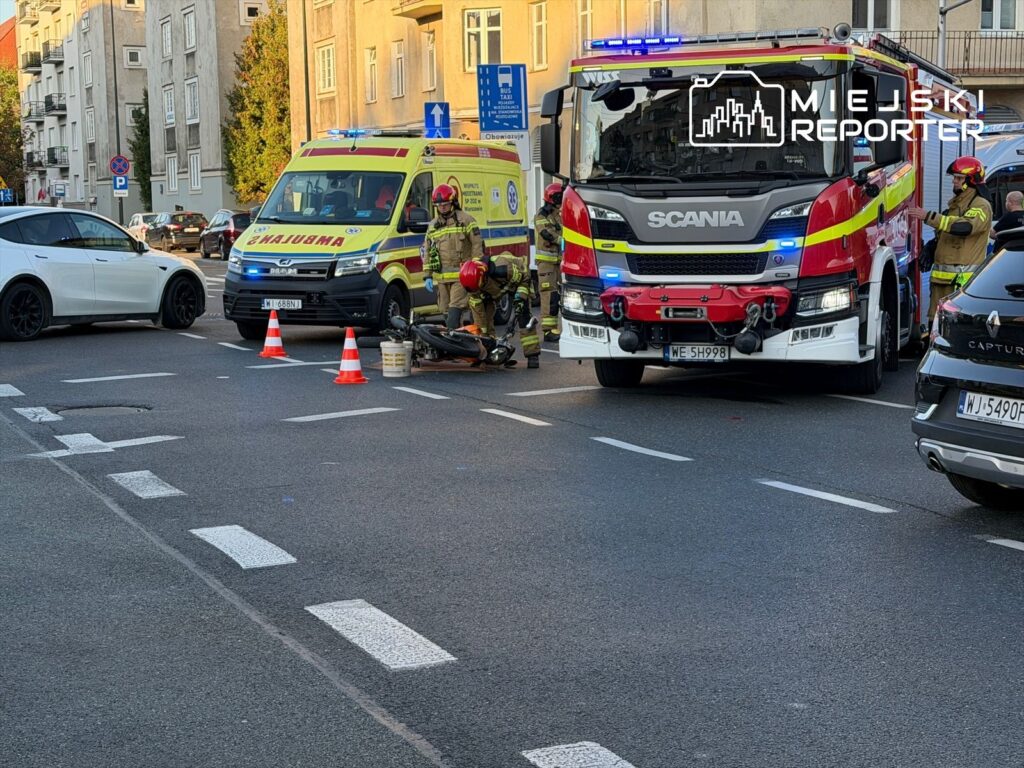 Motocykl, który uległ uszkodzeniu w wyniku wypadku zabezpieczany przez strażaków.