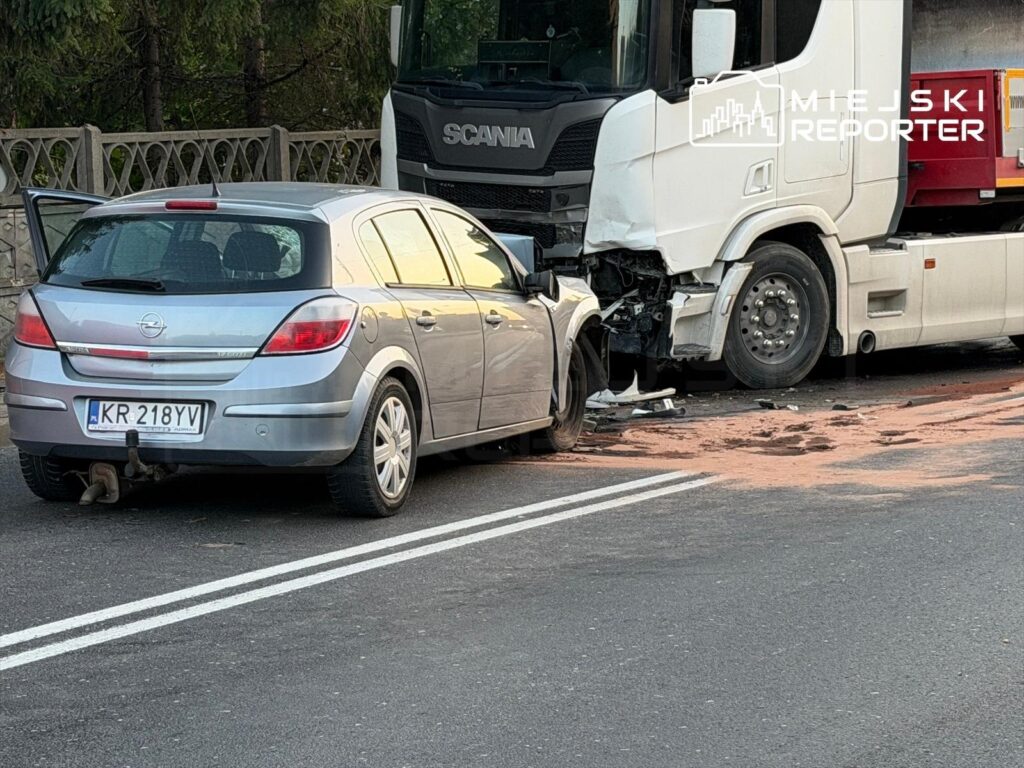 Zderzenie samochodu osobowego z ciężarówką na drodze, z uszkodzeniami widocznymi na obu pojazdach.