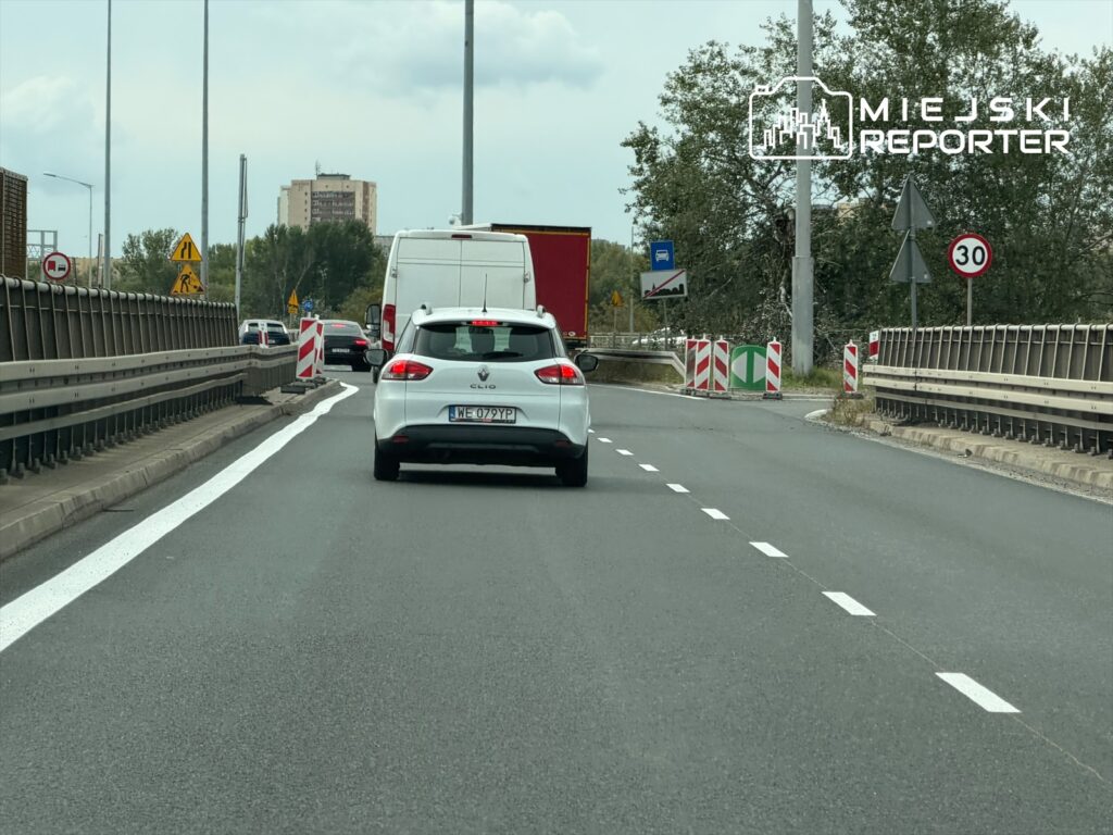 Kierowcy poruszają się dwoma pasami lokalnymi na trasie S8, mijając oznakowanie robót drogowych.