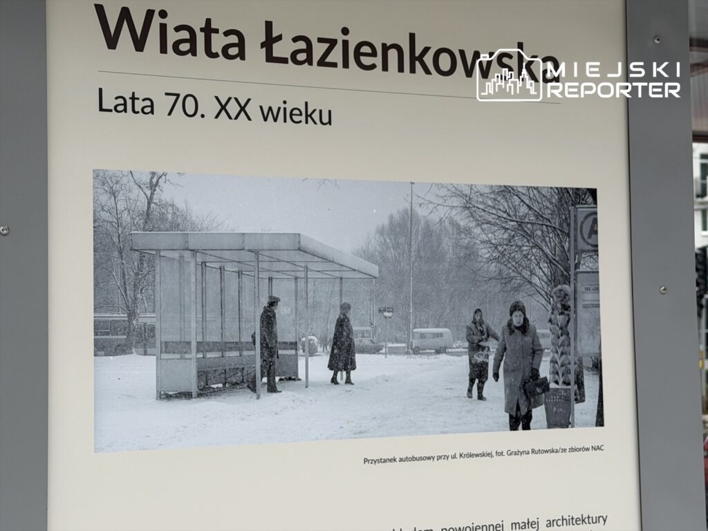 Na przystanku autobusowym w czasie śnieżycy ludzie czekają na transport, otoczeni śniegiem i drzewami.