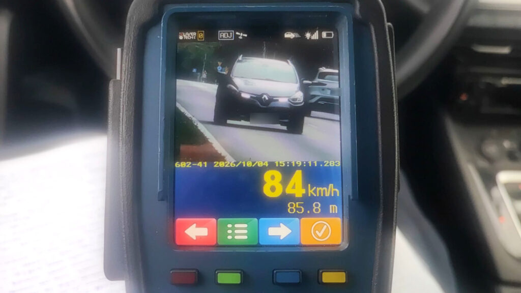 Urządzenie pomiarowe wyświetla obraz samochodu na drodze oraz odczyt prędkości 84 km/h.