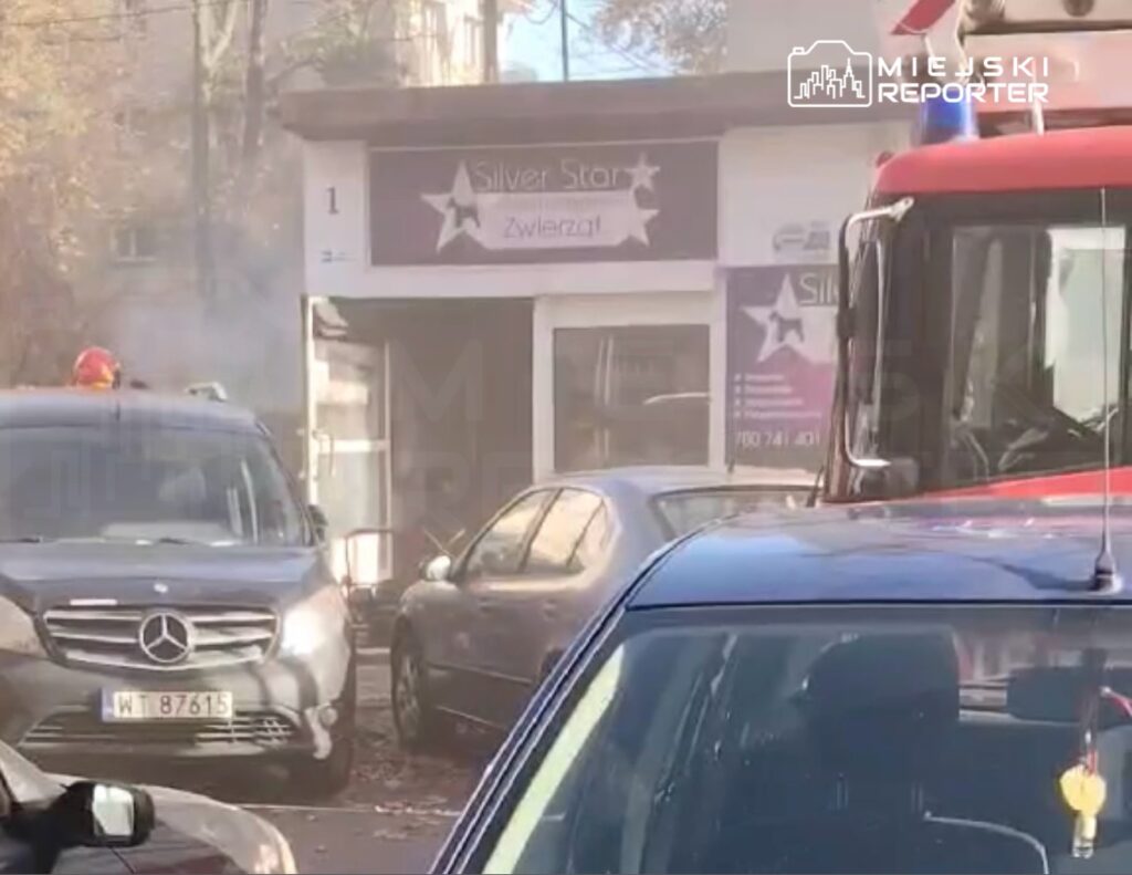 Czerwony wóz strażacki i samochody stoją na ulicy przed sklepem „Silver Star”, wśród dymu.
