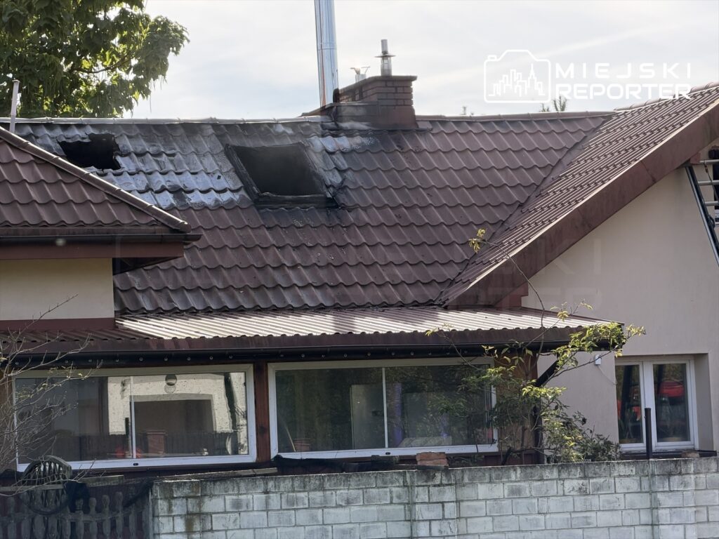Pożar uszkodził dach domu; na czerwonej dachówce widać okopcone ubytki i wybity otwór.
