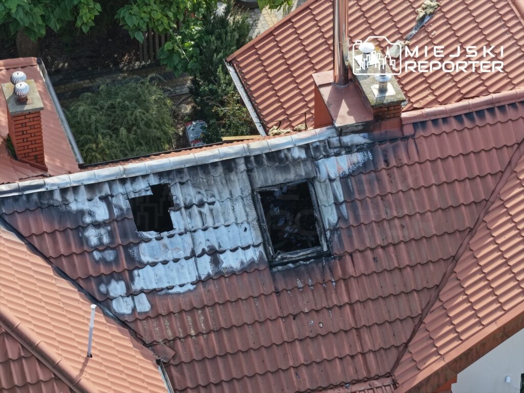 Pożar uszkodził dach domu, okopcone dachówki i wybite okna widać z góry.
