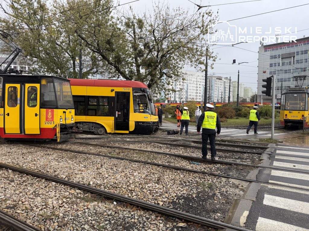 Żółto-czerwone tramwaje stoją na torowisku, a obok nich pracują służby w kamizelkach odblaskowych.