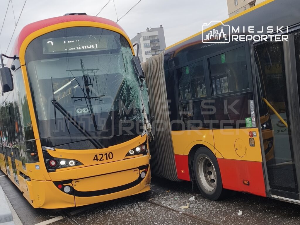 Żółty tramwaj i czerwono-żółty autobus stoją uszkodzone obok siebie na torowisku miejskim.
