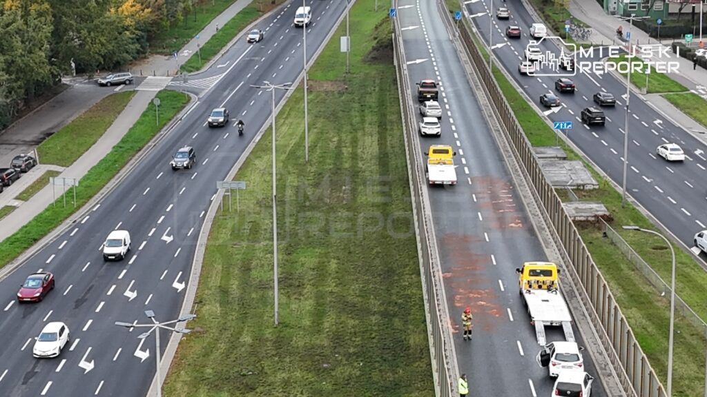 Z lotu ptaka widać ruchliwe jezdnie, a na jednej z nich ślady zdarzenia i służby drogowe.